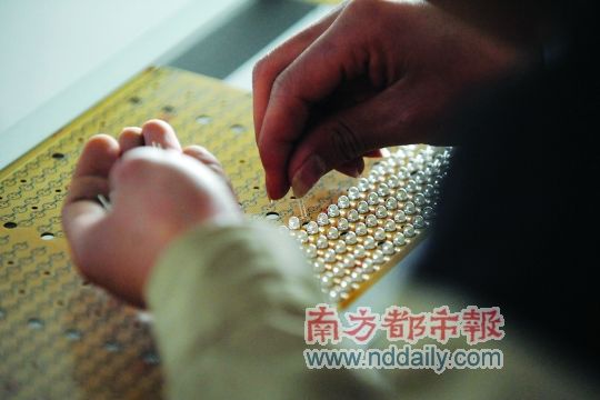 工人忙著安裝用于燈具發(fā)光的LED燈珠，這類工作處于LED燈具生產(chǎn)的最下游。資料圖